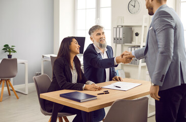 Male lawyer, real estate agent or financial advisor shaking hands with mature man in office. Family couple and lawyer, realtor shaking hands making deal, investment or greeting at meeting