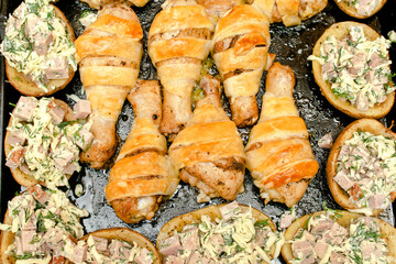 Baked fried roasted chicken legs,drumsticks meat wrapped in puff pastry,dough, pita bread and potatoes filled with sausages and cheese in oven,step by step instruction