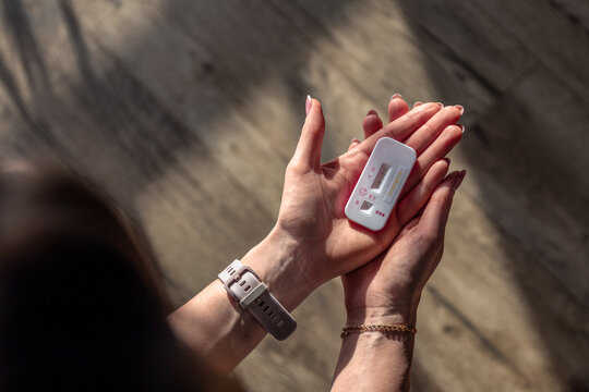 woman holding a pregnancy test, representing reproductive health, excitement, worry, hope, and anticipation. The image is related to pregnancy, motherhood, family planning, home testing, diagnosis, a
