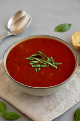 Homemade Tomato Basil Soup in a Bowl, side view. Close-up.