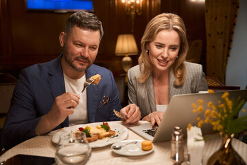 Couple eating in lobby-bar and watching tv show