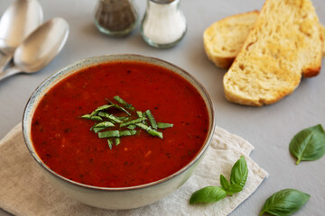 Homemade Tomato Basil Soup in a Bowl, side view. Close-up.