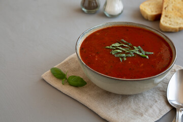 Homemade Tomato Basil Soup in a Bowl, low angle view. Copy space.