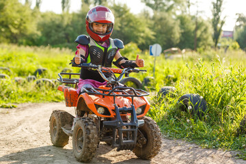A child rides a quad bike through the mud. ATV rider rides