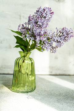 Interior decoration with green vase of lilac flowers bouquet