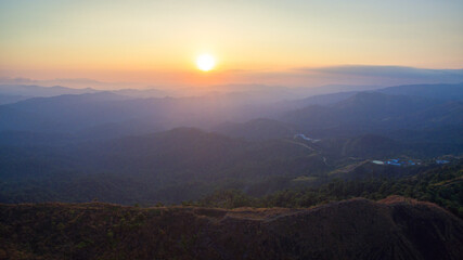 aerial view on the peak in sunset the village far from civilization Traveling on a difficult road..Beautiful sunset view on the hilltop complex..The sun shone through mountain peak after mountain.