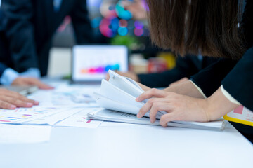 Businesswoman hands working in Stacks of paper files for searching and checking unfinished document achieves on folders papers.