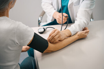 Therapist measures the pressure of an elderly lady