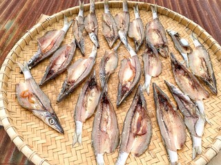Dried fish under the sun on a rattan tray