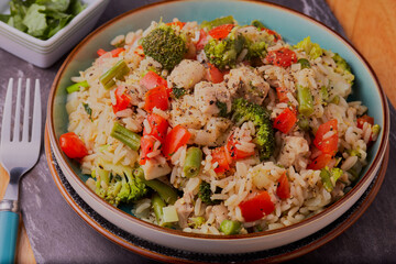 Chicken and vegetables with egg rice and garnished with herbs and seasoning.