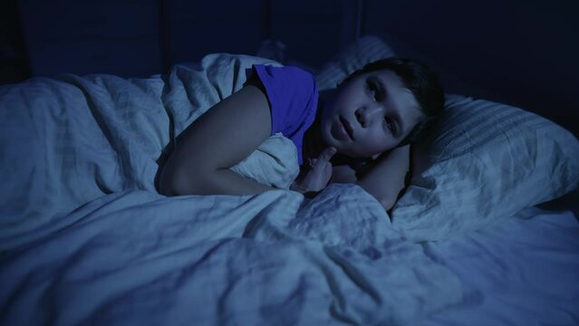 Scared boy in bed at night
