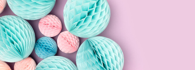 Banner with pink and blue tissue paper balls different sizes on a purple background. Festive composition.