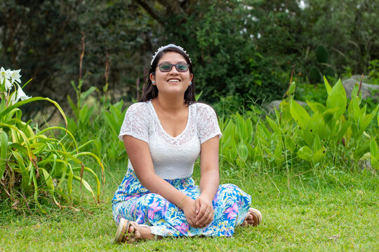 Retrato de una mujer hermosa con gafas de sol sentada en el fondo de la naturaleza. Señora joven atractiva. Imagen 
