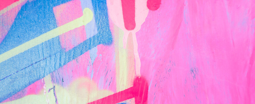Messy paint strokes and smudges on an old painted wall. Purple, blue, pink, magenta, yellow drips, flows, streaks of paint and paint sprays