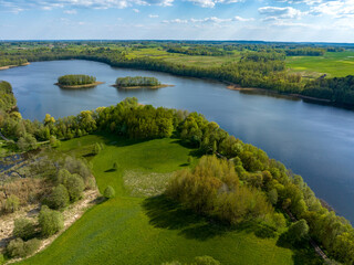 Naklejka na ściany i meble Beautiful drone nature landscape of fields, meadows, forest and lake - sunny day in Poland, Mazury aerial view