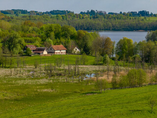 Obraz premium A farm in the countryside with a lake in the background, Poland, Mazury