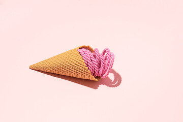 Ice cream made of pink string, creative summer vacation layout, candy pink background.