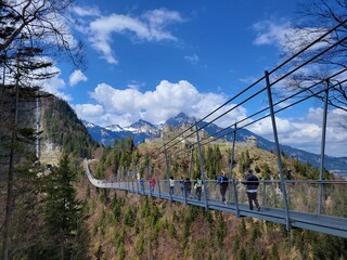 Fototapeta na wymiar Long pedestrian swinging bridge across vast valley in the Alps of western Austria