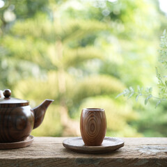 wooden small tea cup and earthenware pot on wooden table outdoor drinking