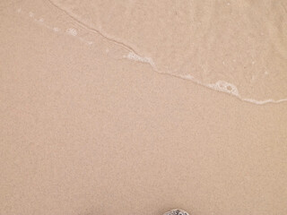 Sea water on sandy beach sand - nature background.