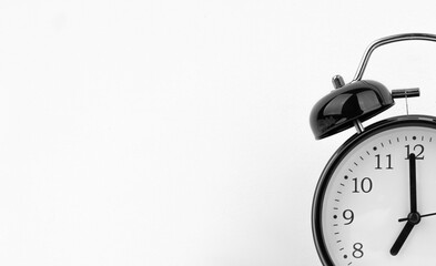 Black alarm clock on white wall background