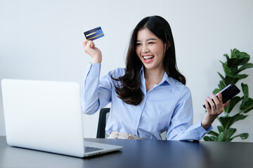 Naklejka premium attractive asian woman shopping online with a credit card