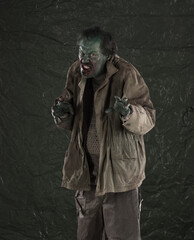 Angry bloody zombie man on dirty background