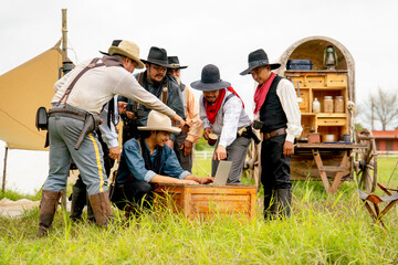 Group of cowboy men stay in field and enjoy about using laptop to work or communicate with other people.