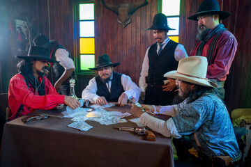 Close up view group of cowboy men enjoy to play card in room together and someone is smoking also...