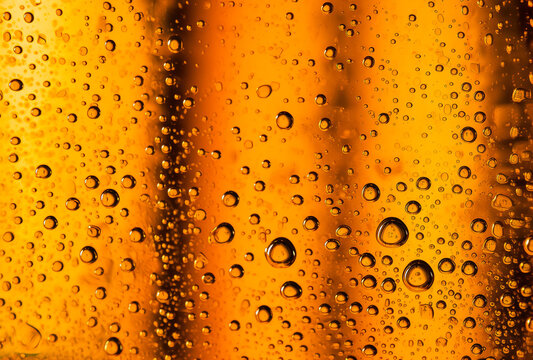 A close up of water droplets on a yellow surface. The concept of cold cooling drinks on hot days. Generative ai
