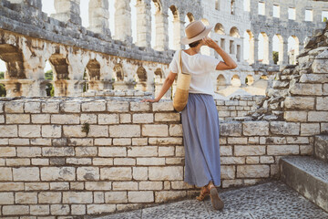 Beautiful tourist woman visiting the sights in Pula, Croatia. Vacation in Europe at summertime.