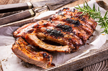 Barbecue veal spare ribs with hot honey chili marinade served as close-up on a design stone tray