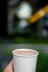 Hand holding a cup of hot chocolate with latte art