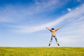 Woman jumping on green field
