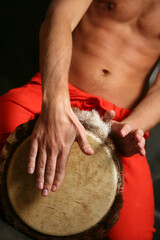 Man playing the djembe (nigerian drum) in studio
