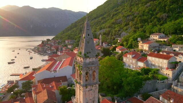 A stunning aerial view of the charming city of Perast in Montenegro, where the Bell Tower in the church of Saint Nikolas stands out as a focal point. Shot using a drone, the footage captures the city