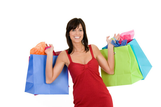 Excited Caucasian woman holding shopping bags and smiling on white background