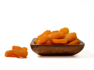 Wooden bowl of dried apricots on a white background, selective focus. Dried apricots close up.