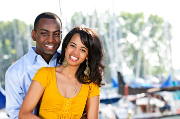 Young romantic couple hugging and standing at harbor