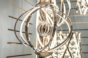 Reflection of an unknown person in a crystal decorative element of a hanging gold LED lamp in an...