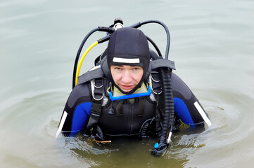 Fototapeta na wymiar Scuba diver in wet suit entering the cold water