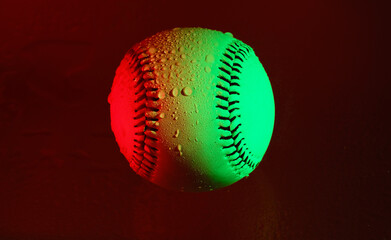 Red and green creative lighting on baseball with water droplets for rain game concept.