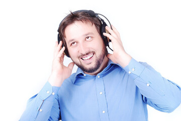 Isolated white man in blue shirt is listening to music on headphones