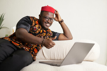 Online Communication. African Guy In Traditional Shirt Having Video Call On Laptop