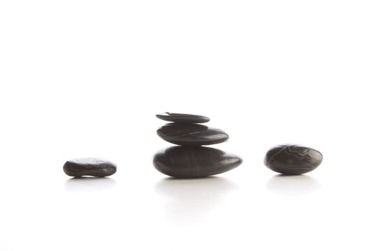 Isolated black massage spa stones on white surface