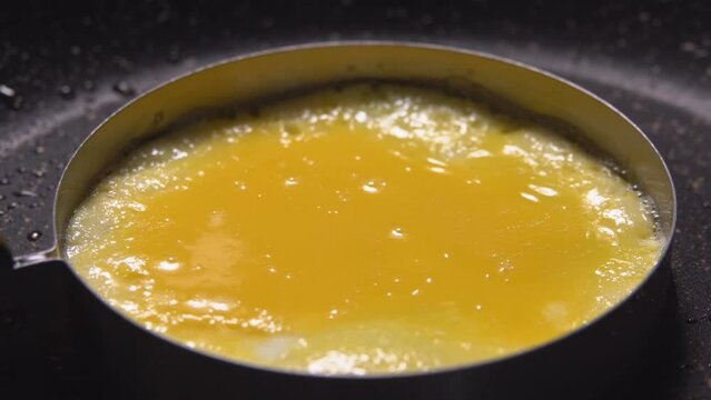 Egg yolk is fried in a frying pan in mold