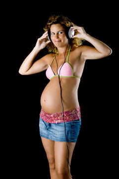 Beautiful pregnant woman listen music with head phones