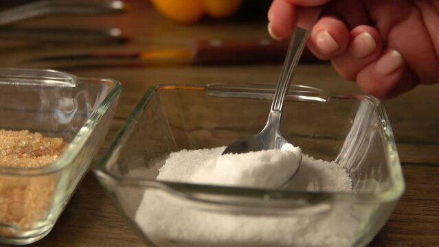 A teaspoon scoops up salt from a glass saucer