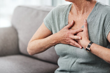 Heart attack, chest pain and sick senior woman with asthma in her home living room or couch with an...