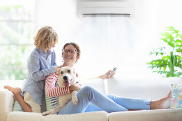 Mother and child with air conditioner remote